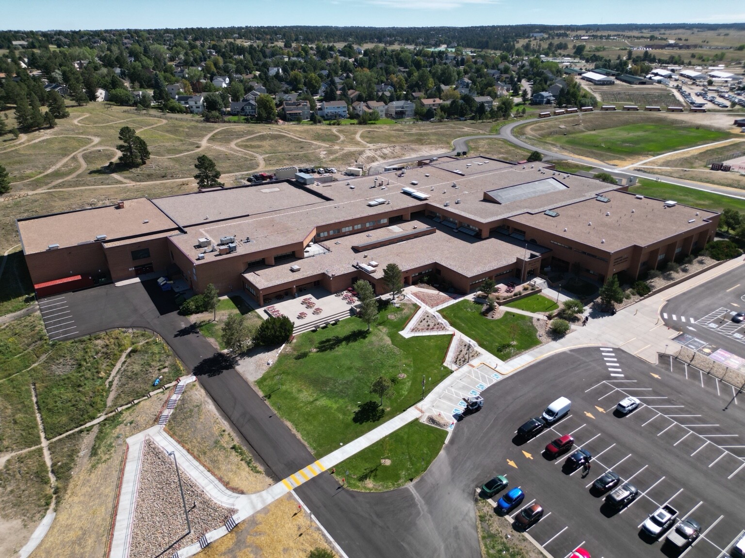 Aerial overview of a large property, parking areas, access routes, and surrounding site context