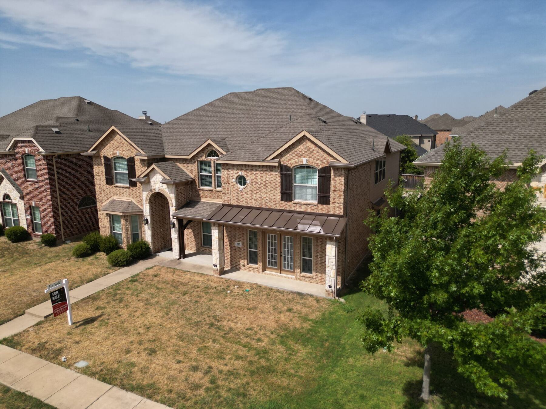Elevated wide aerial photograph of a home and adjacent properties